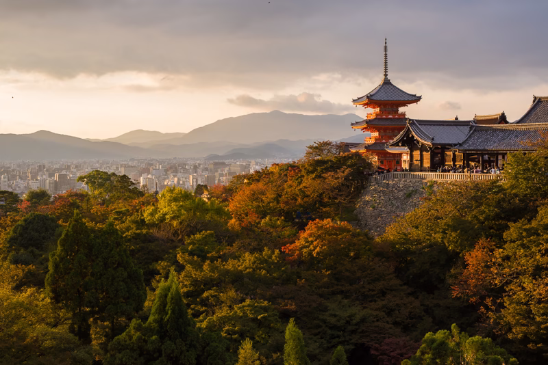 Pagoda chrámu Kijomizu-dera nad podzimním Kjótem při západu slunce
