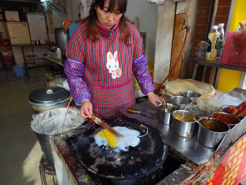 Žena pripravujúca tradičnú čínsku raňajkovú placku