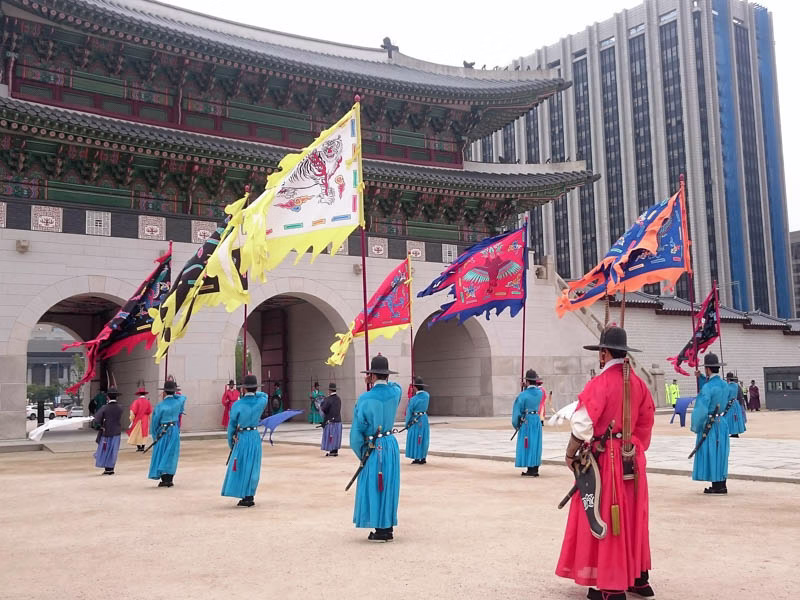 Střídání palácových stráží v dobových uniformách před palácem Gyeongbokgung v Soulu