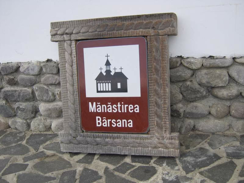 Hnědá cedulka označující historickou památku u rumunské silnice