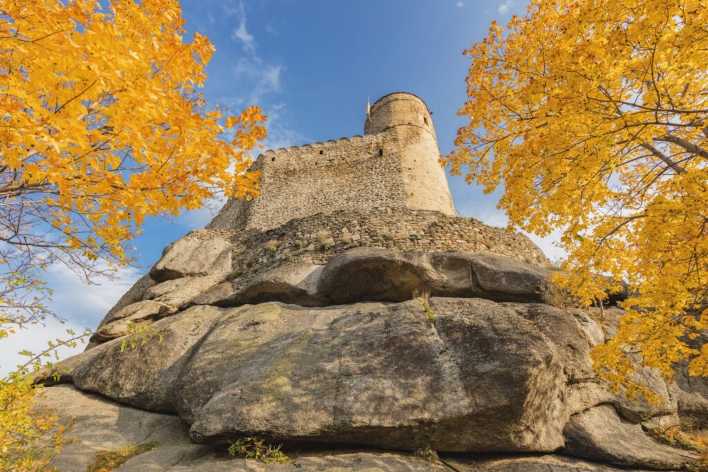 Hrad Chojnik na skalnatém vrcholu obklopený podzimními stromy, Krkonošský národní park