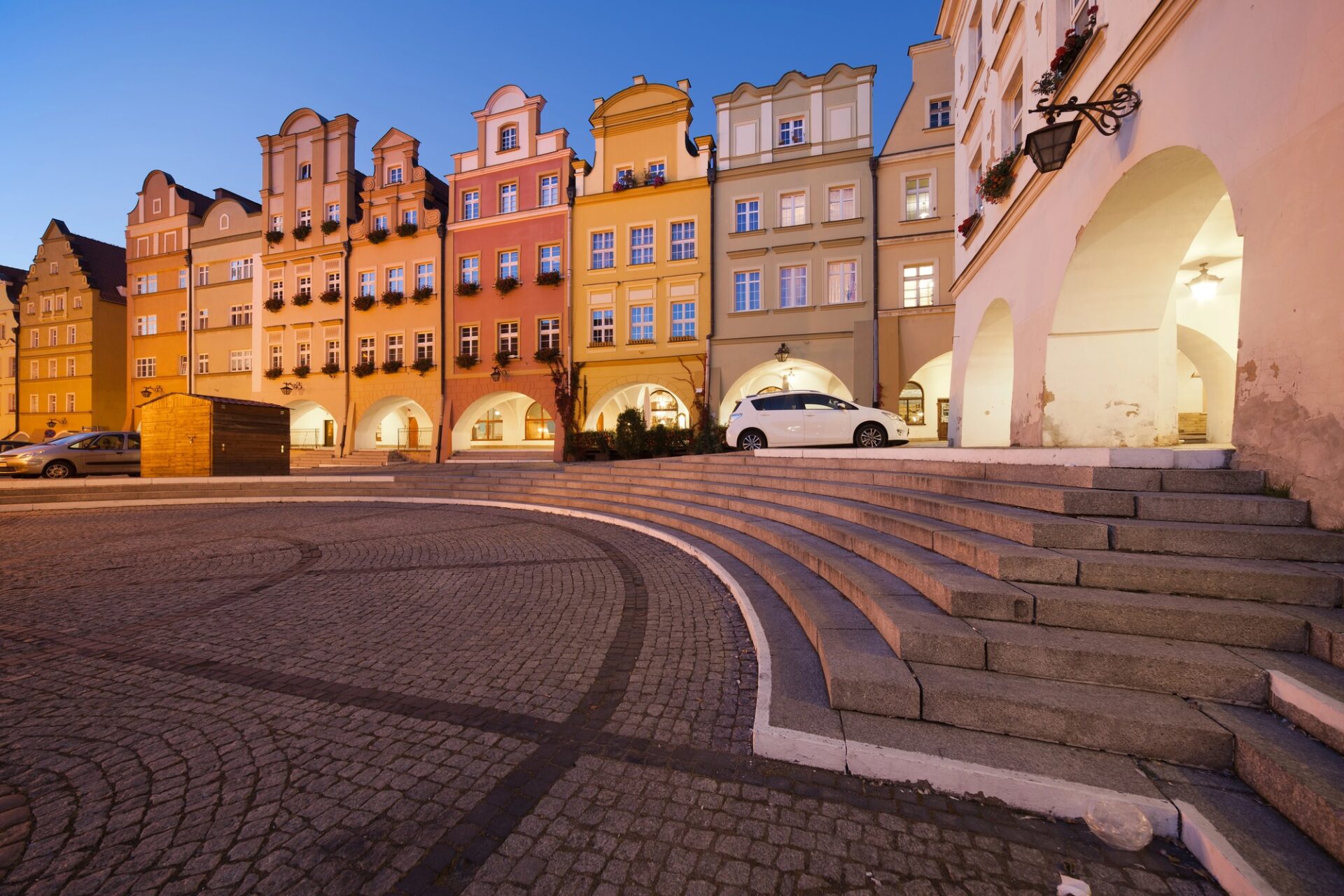 Radniční náměstí (Plac Ratuszowy) v Jelení Hoře v noci s osvětlenými arkádovými domy