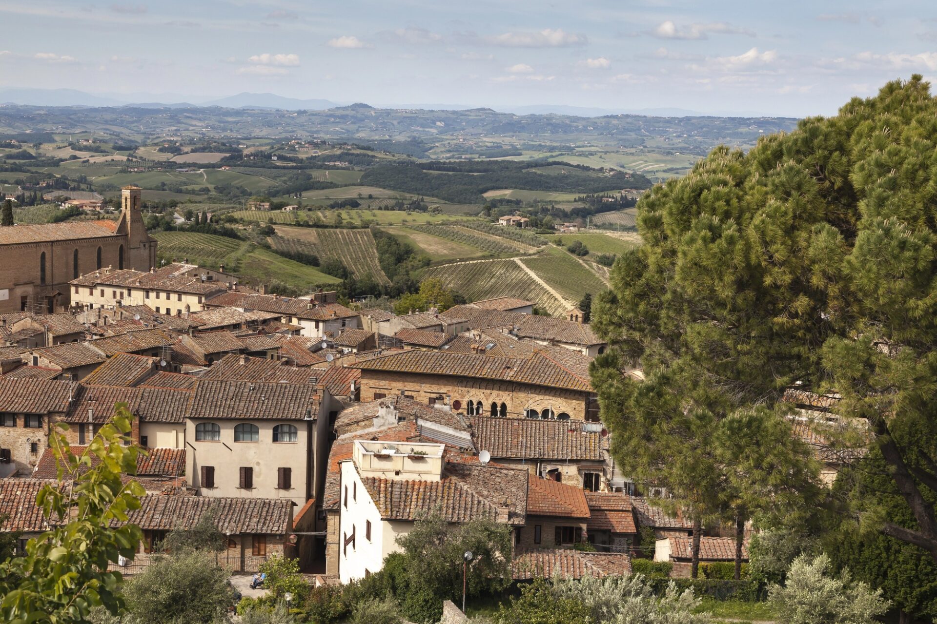 Panoramatický výhled přes střechy San Gimignana na toskánskou krajinu