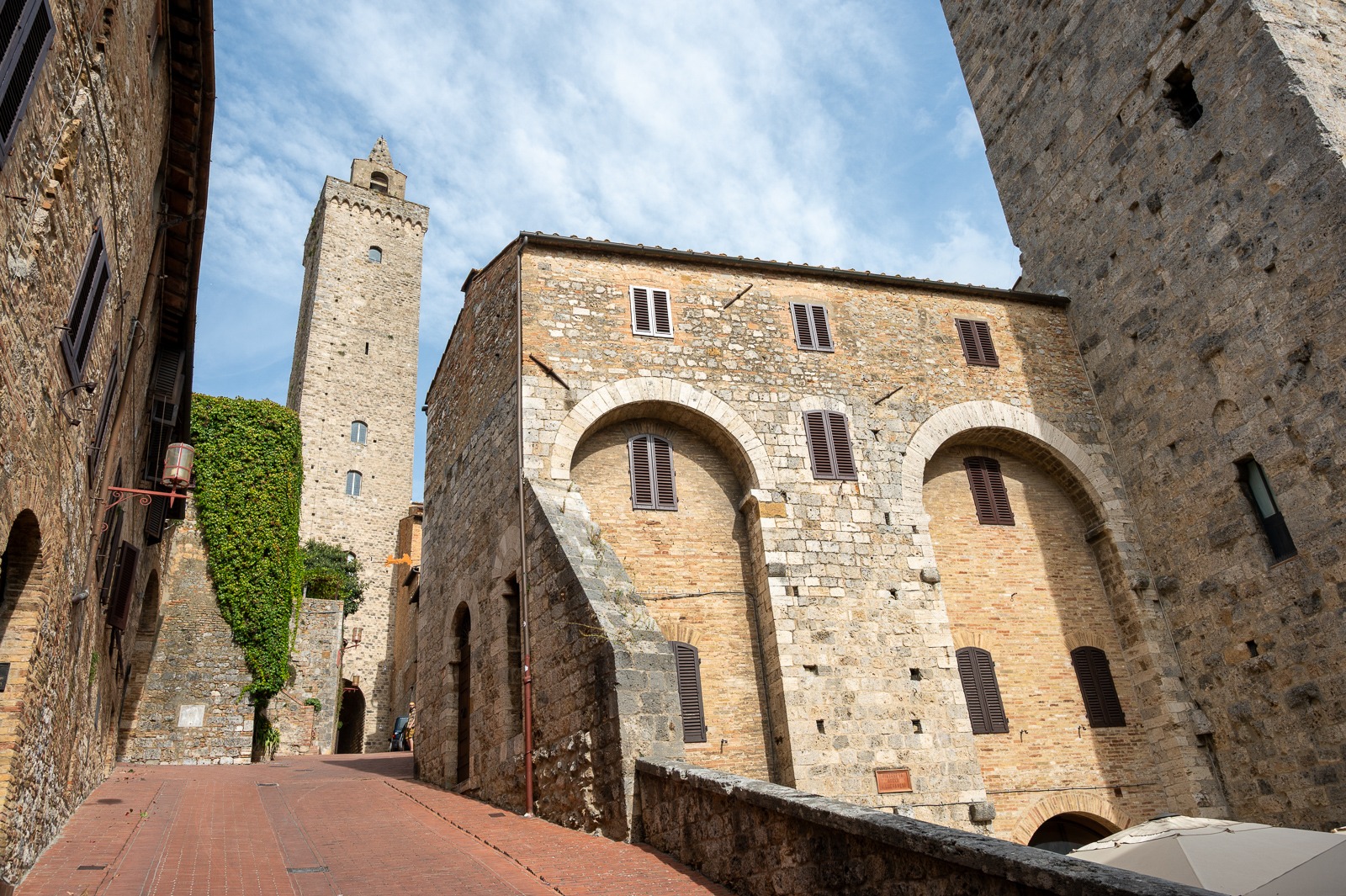 Středověká ulice San Gimignana s věží v pozadí