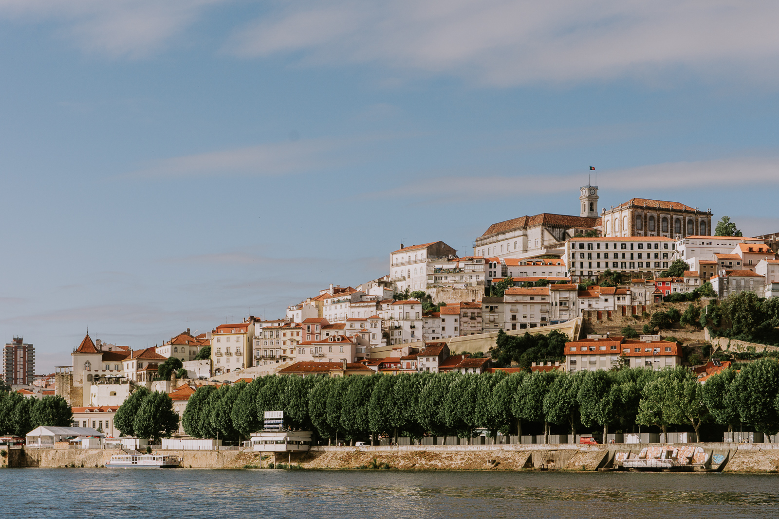 Panorama Coimbry od řeky Mondego s univerzitou na vrcholu kopce