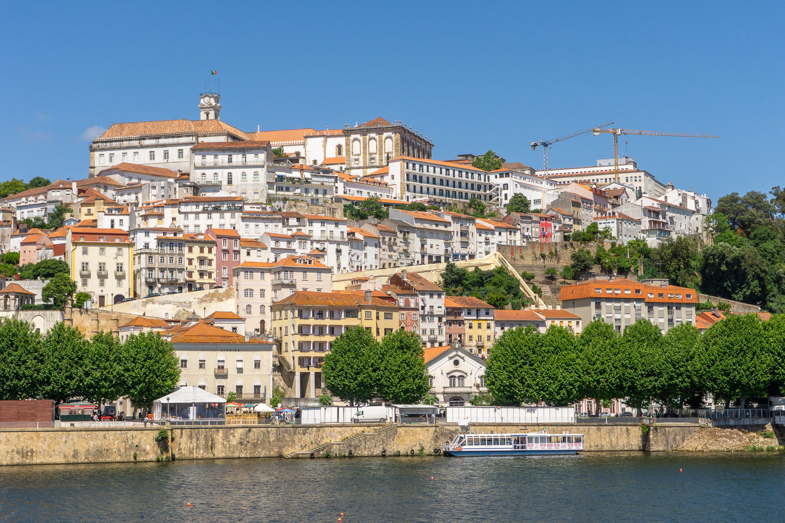 Panorama Coimbry přes řeku Mondego s vyhlídkovou lodí