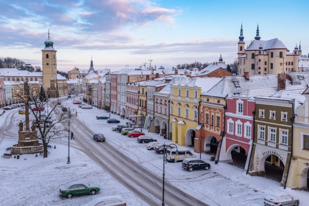 Zasněžené Smetanovo náměstí v Litomyšli s věží radnice a piaristickým kostelem