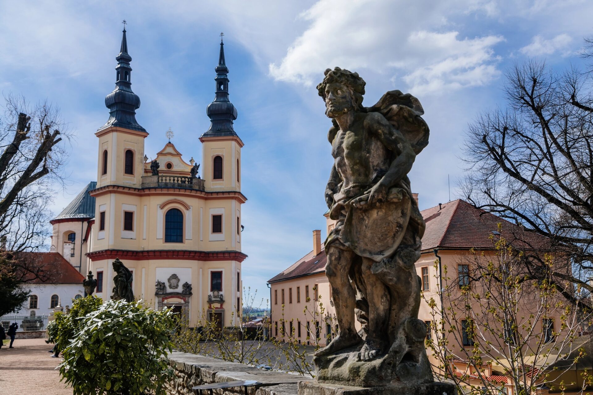 Piaristický kostel Nalezení svatého Kříže v Litomyšli s barokní sochou v popředí