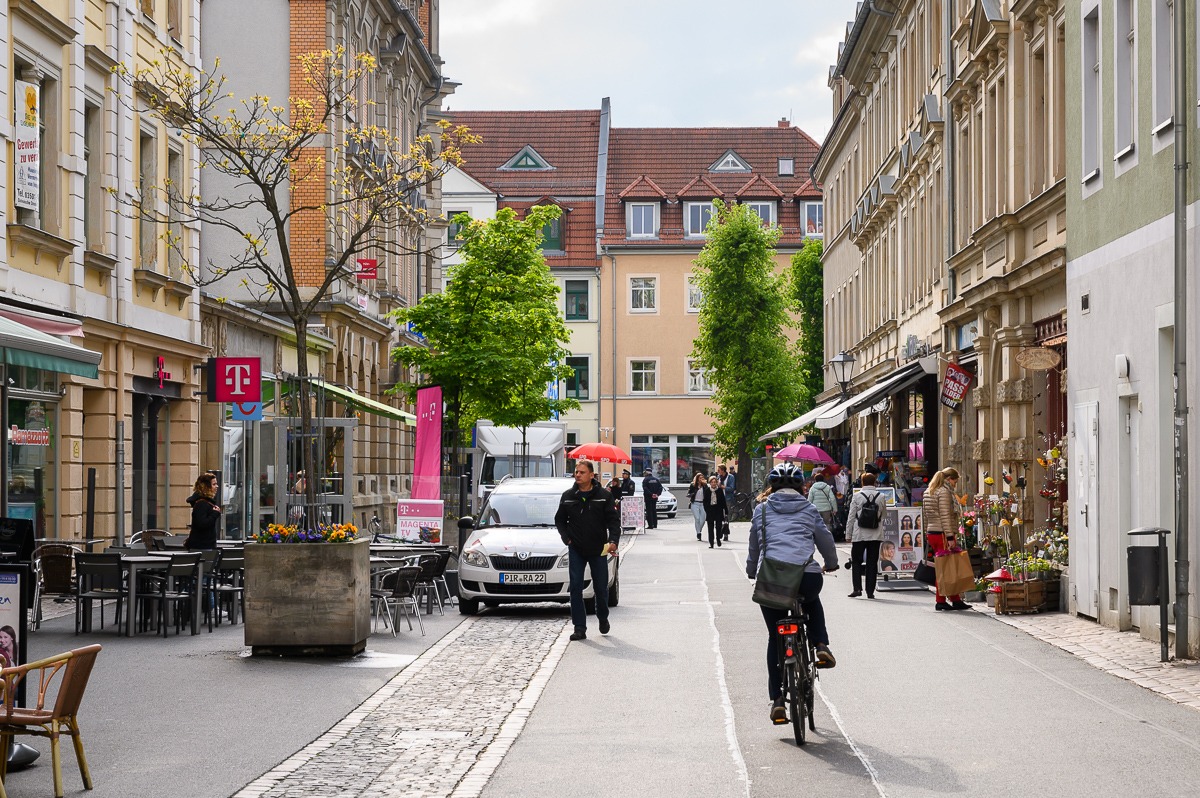 Hlavní ulice v centru Pirny s lidmi a cyklisty