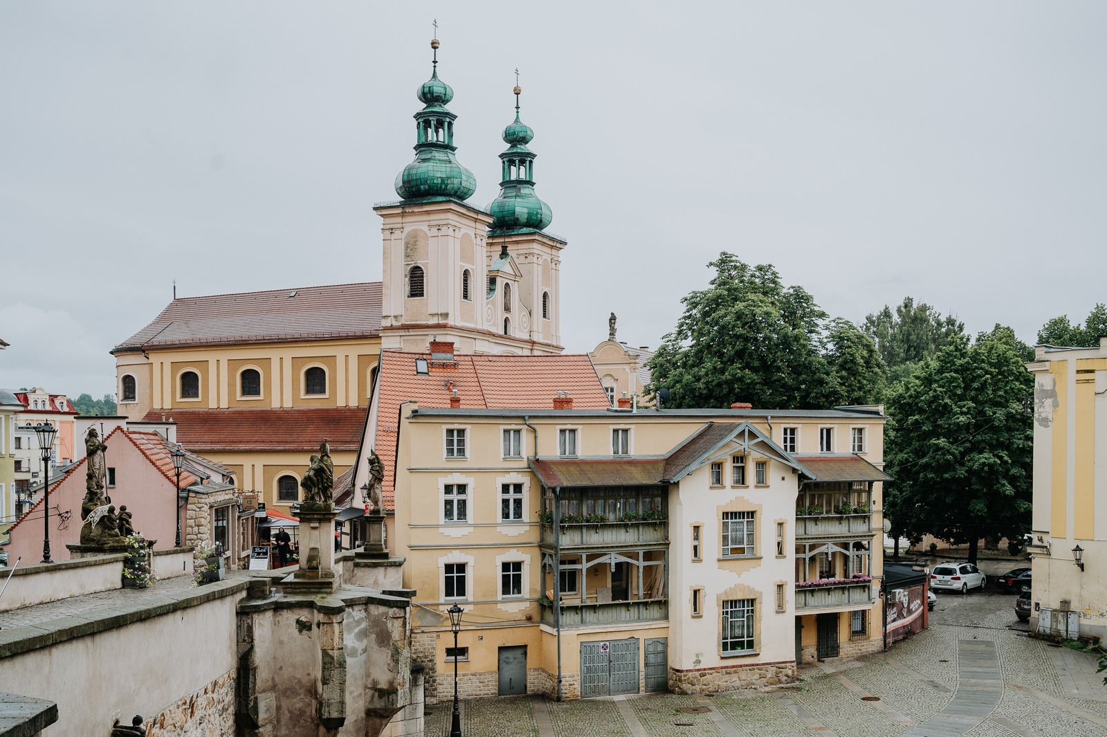 Barokní kostel Panny Marie Růžencové se dvěma věžemi v Kladsku od gotického mostu