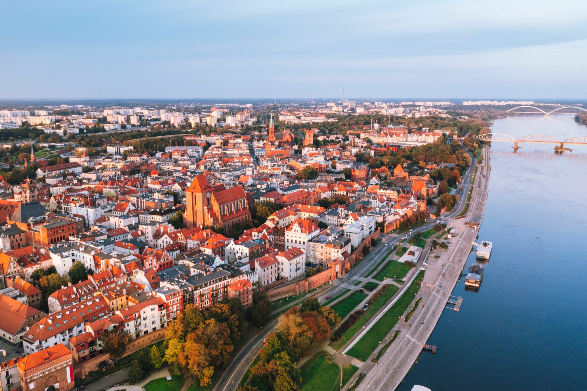 Letecký pohled na staré město Toruň s řekou Vislou a historickými věžemi při západu slunce