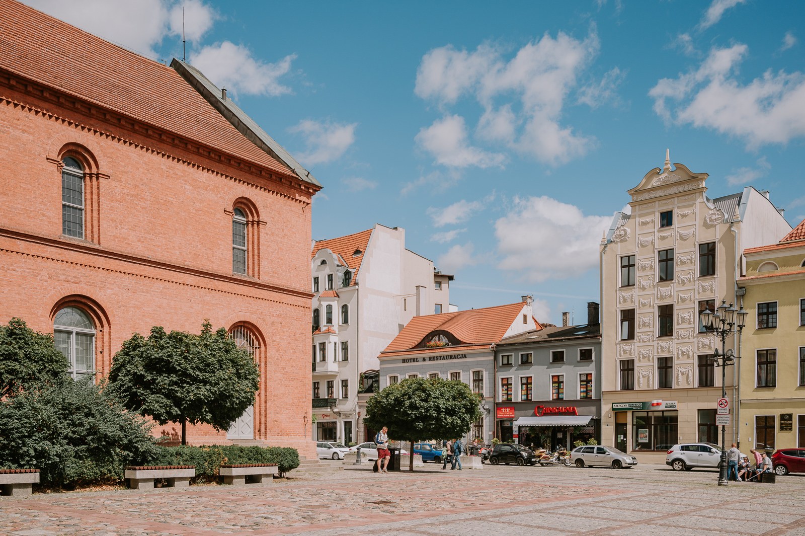 Historické náměstí v centru Toruně s barevnými měšťanskými domy a cihlovou stavbou