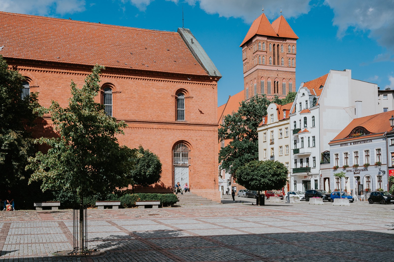 Osvětlená nákupní ulice v centru Toruně za soumraku