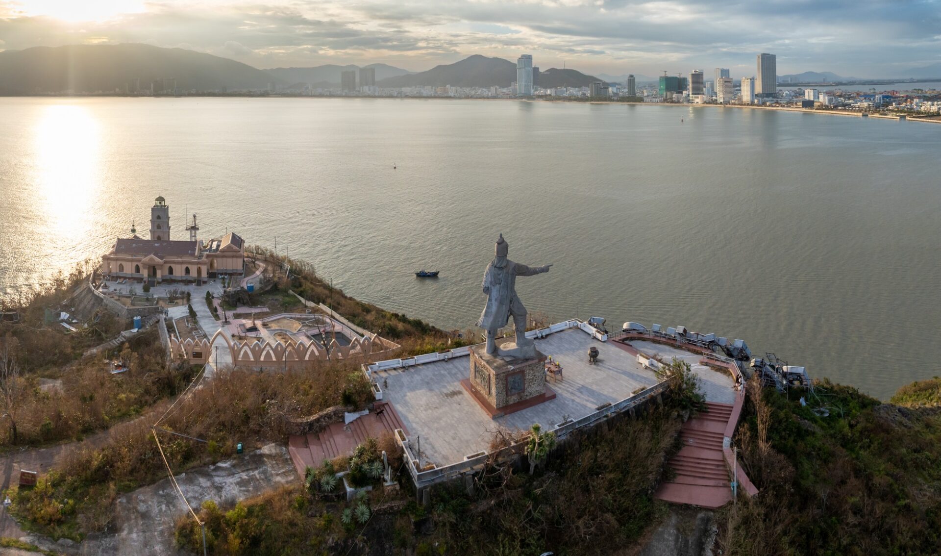 Socha Tran Hung Daa nad městem Quy Nhon při západu slunce