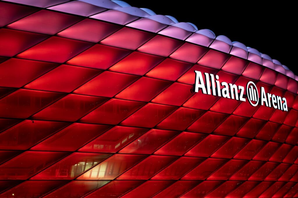 Allianz Arena v Mnichově osvětlená červeně během večerního zápasu Bayernu