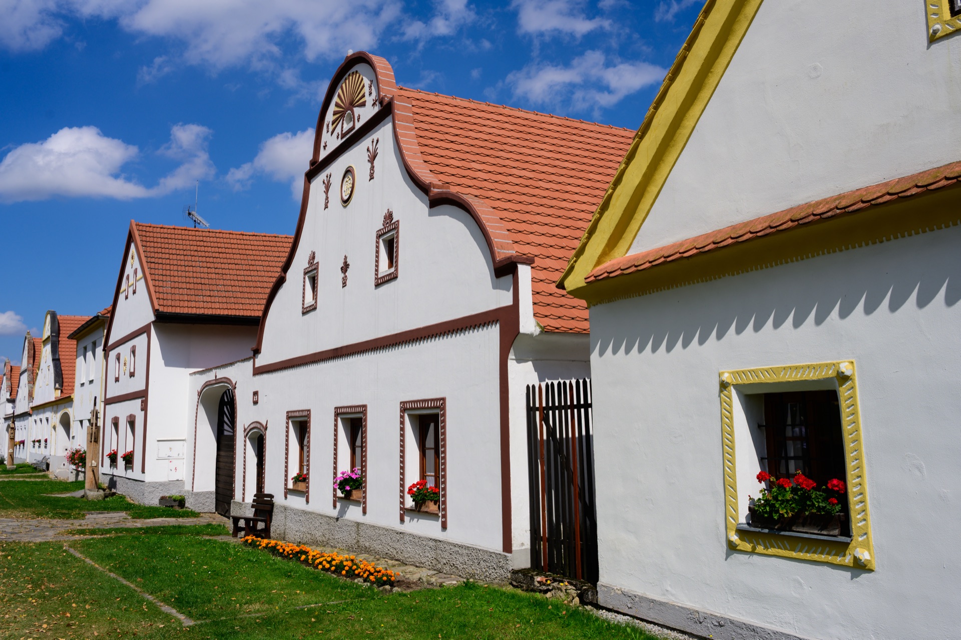 Zdobené štíty a zděná vjezdová brána usedlosti v UNESCO vesnici Holašovice