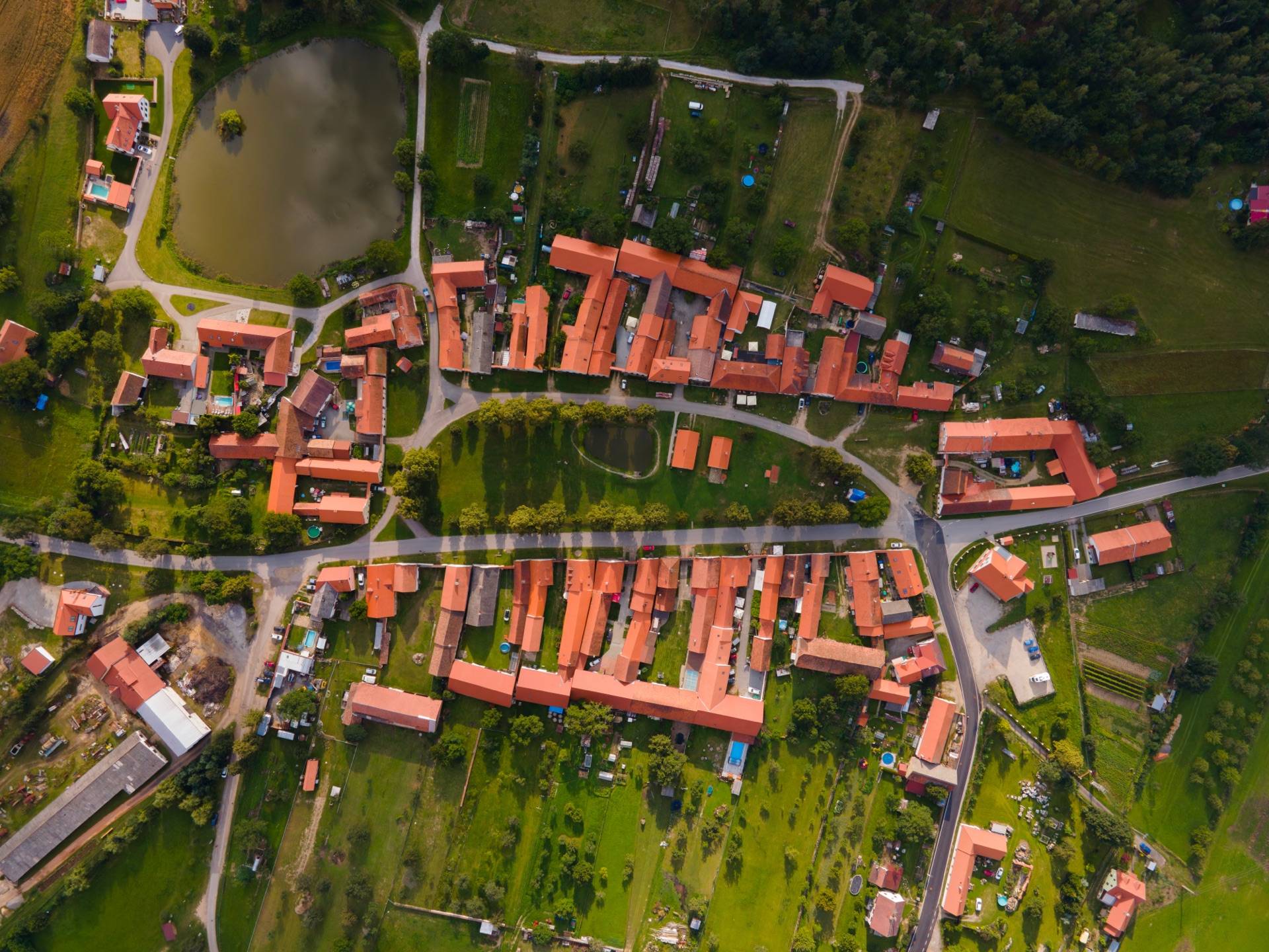 Letecký pohled na UNESCO vesnici Holašovice s obdélníkovou návsí a dvěma řadami statků