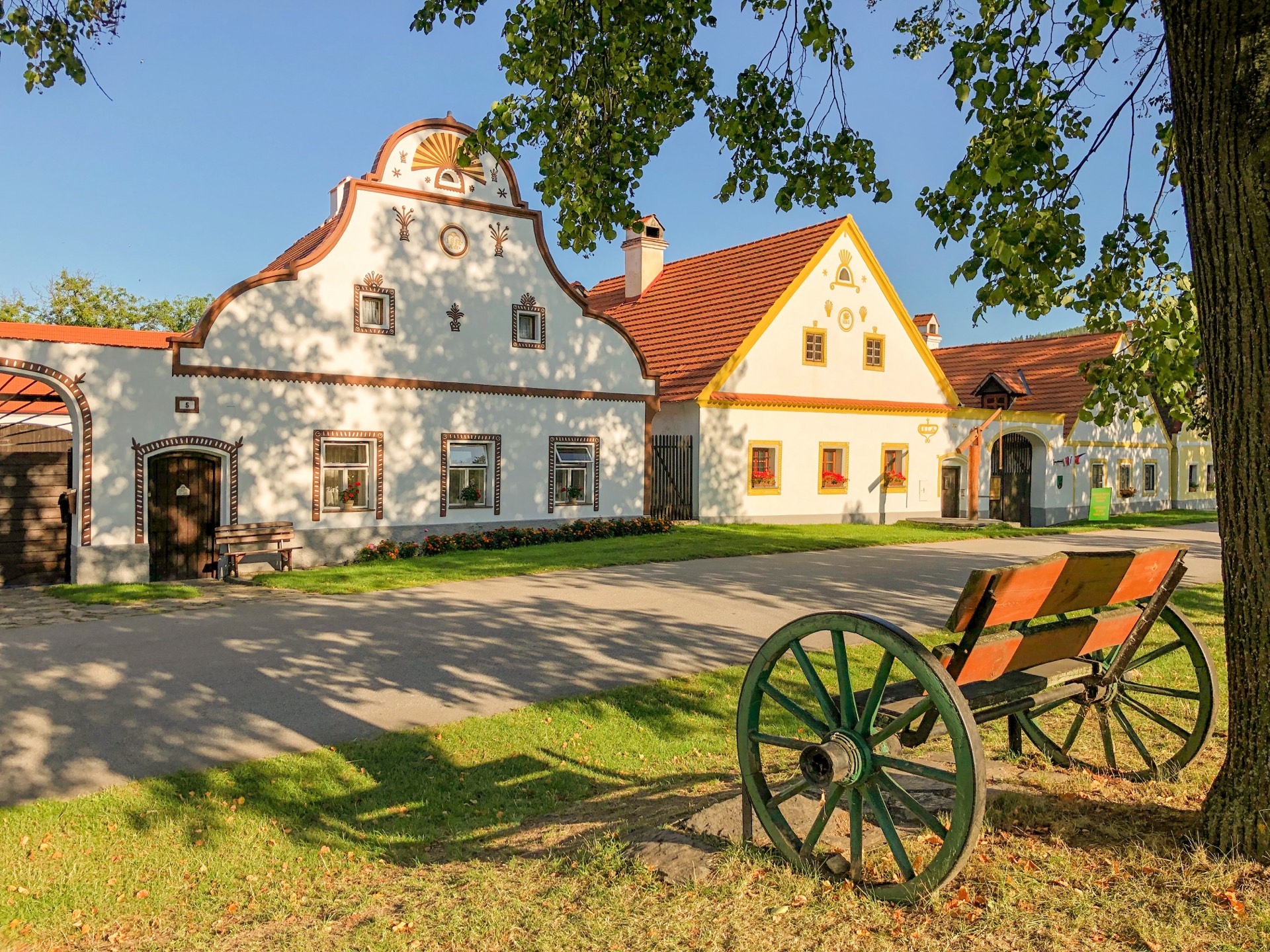 Zdobené štíty usedlostí v Holašovicích ve večerním světle