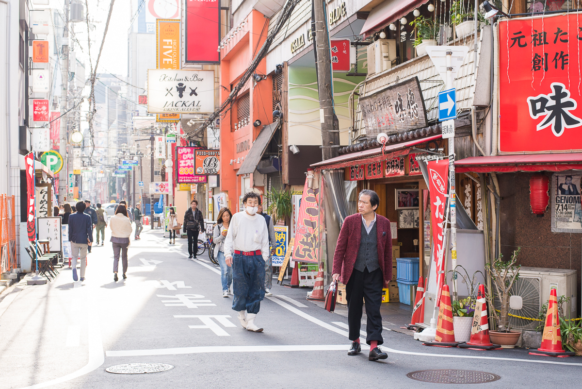 Běžná japonská ulice s restauracemi, cedulemi a chodci