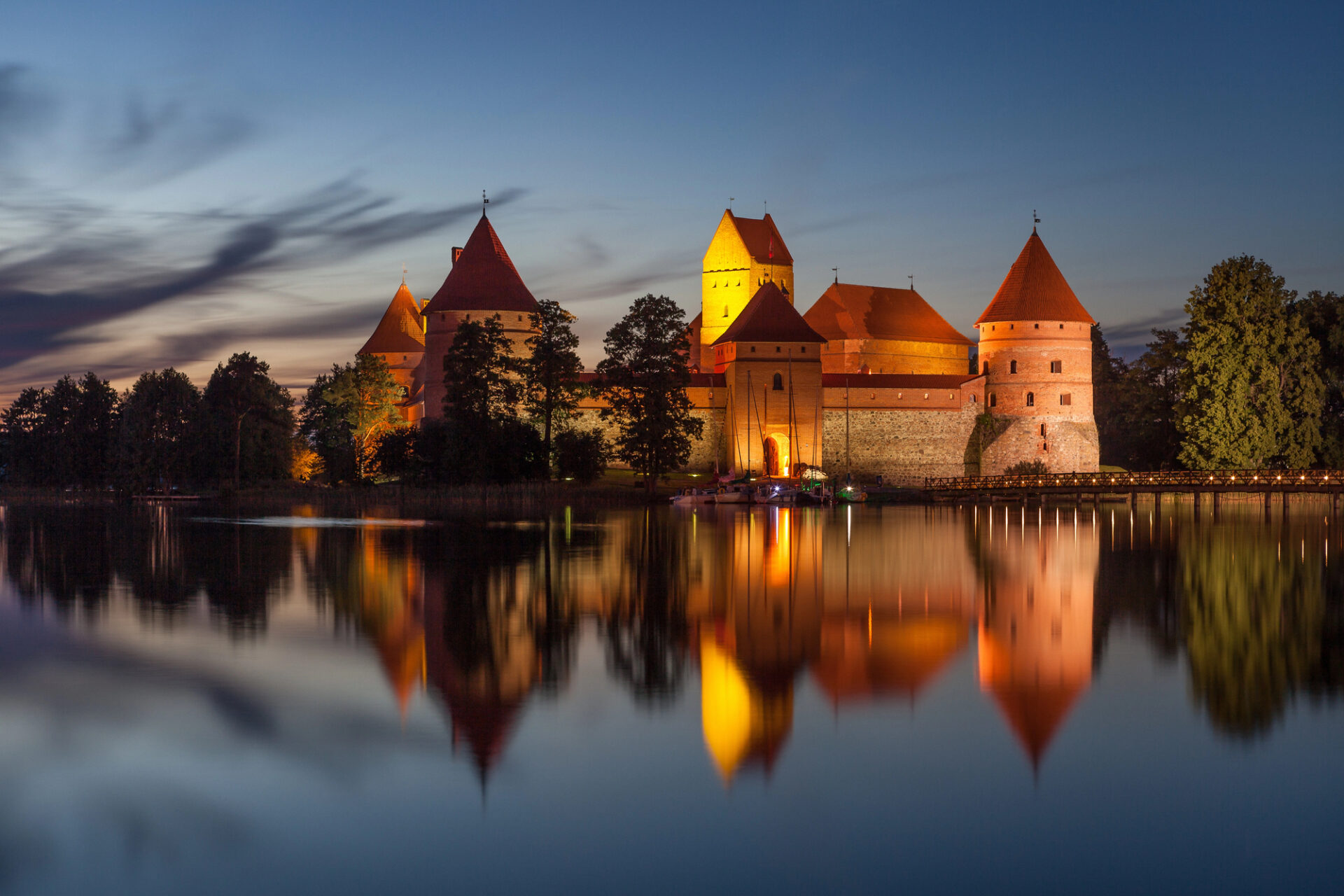 Hrad Trakai nasvícený po setmění a jeho odraz v jezeře Galvė