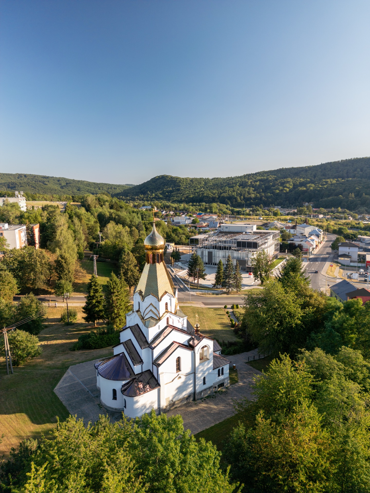 Pravoslavný chrám svatého Ducha se zlatou kopulí a v pozadí budova Muzea Andyho Warhola v Medzilaborcích