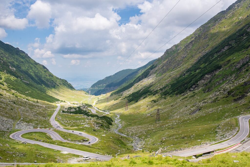 Serpentiny silnice Transfăgărășan stoupající zeleným údolím rumunských Karpat