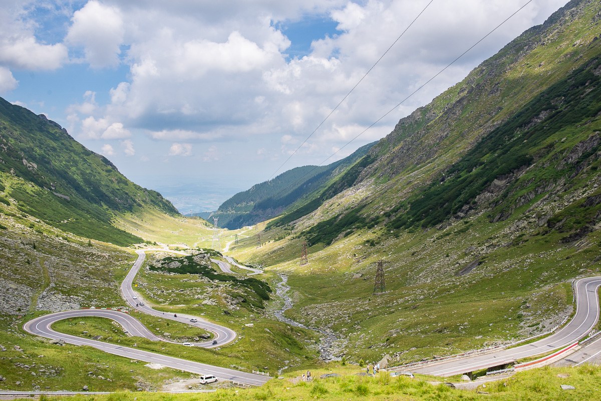Serpentiny silnice Transfăgărășan stoupající zeleným údolím rumunských Karpat