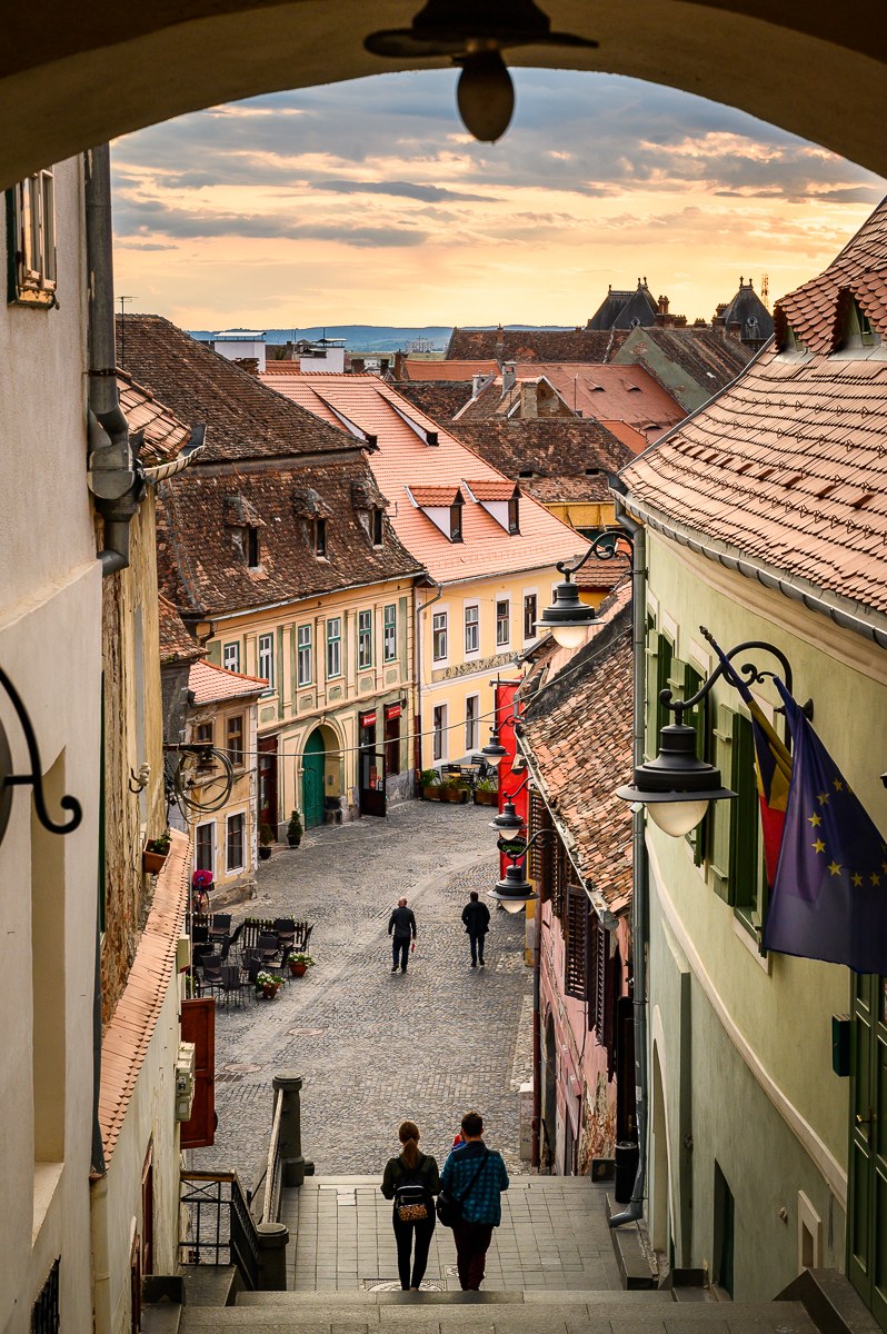 Dlážděná ulička v dolním městě Sibiu se schody a lucernami