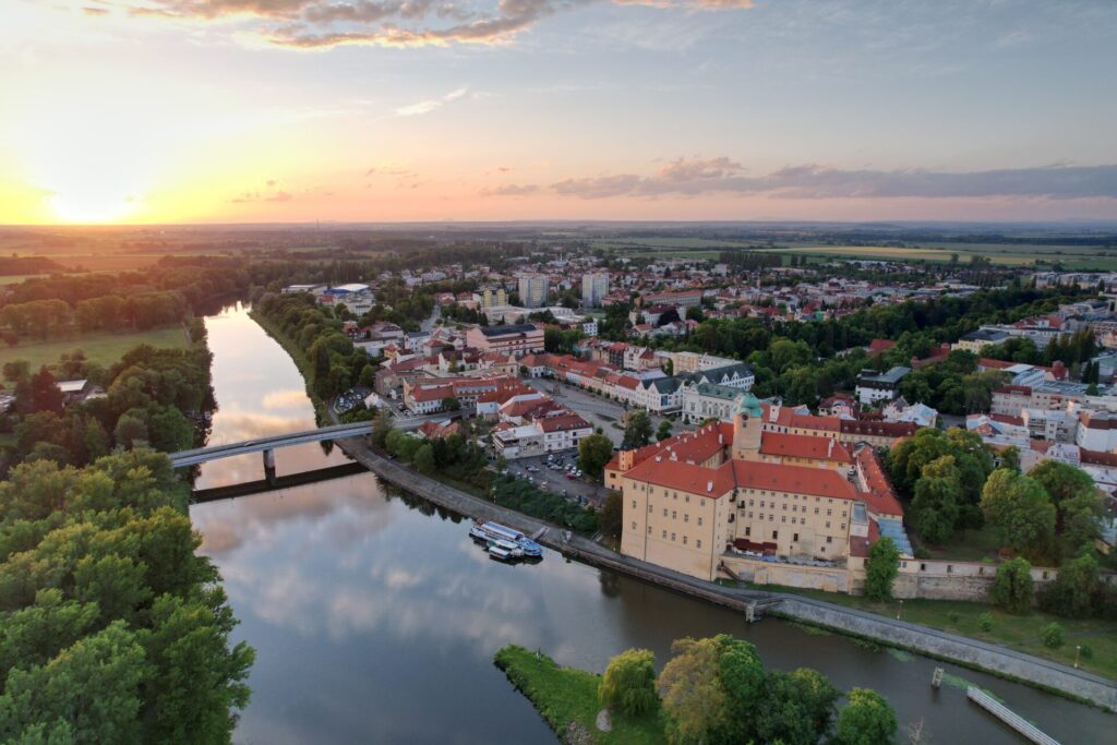 Letecký pohled na lázeňské Poděbrady se zámkem a řekou Labe za východu slunce