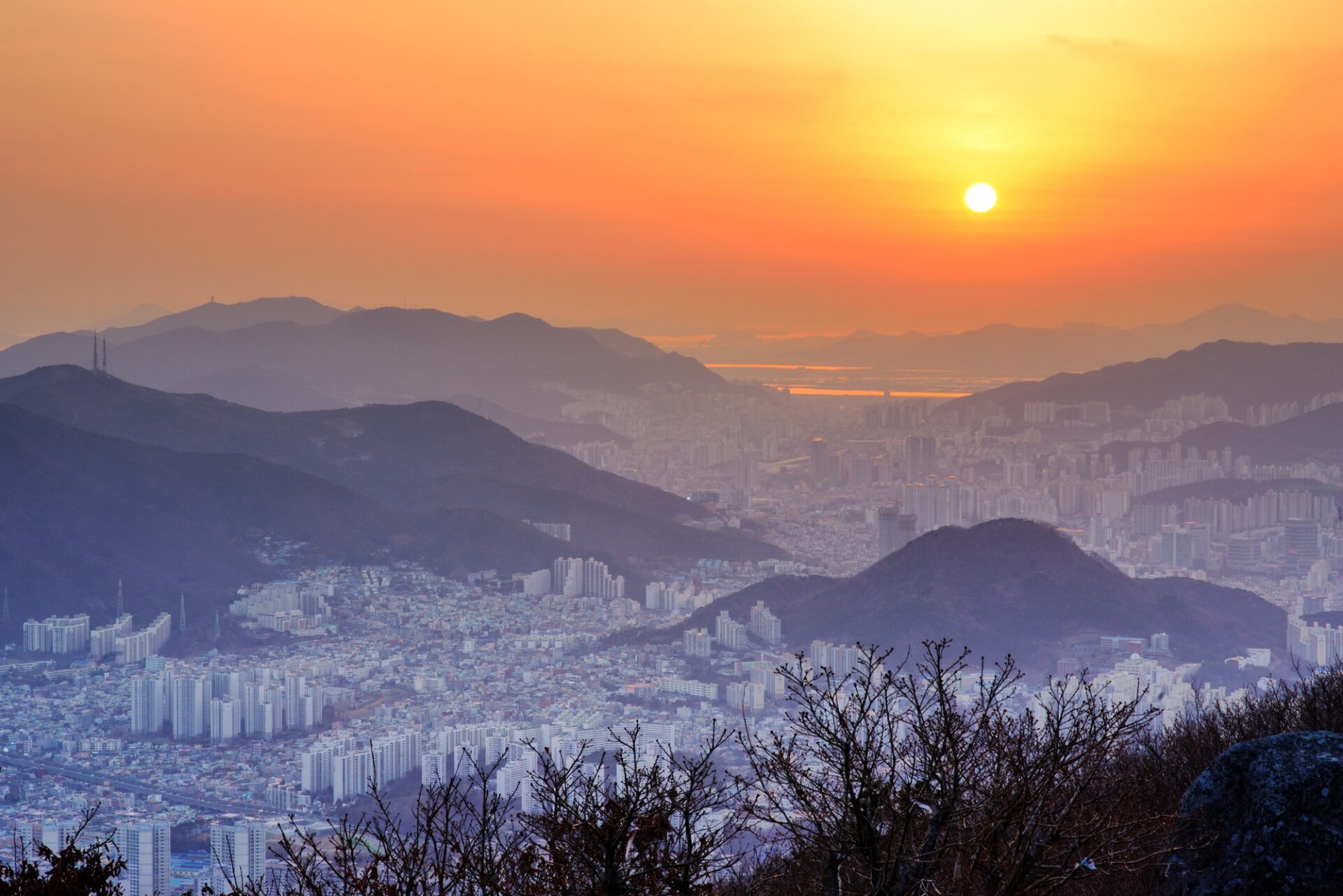 Noční panorama Busanu s horami, čtvrtí Haeundae a světly města