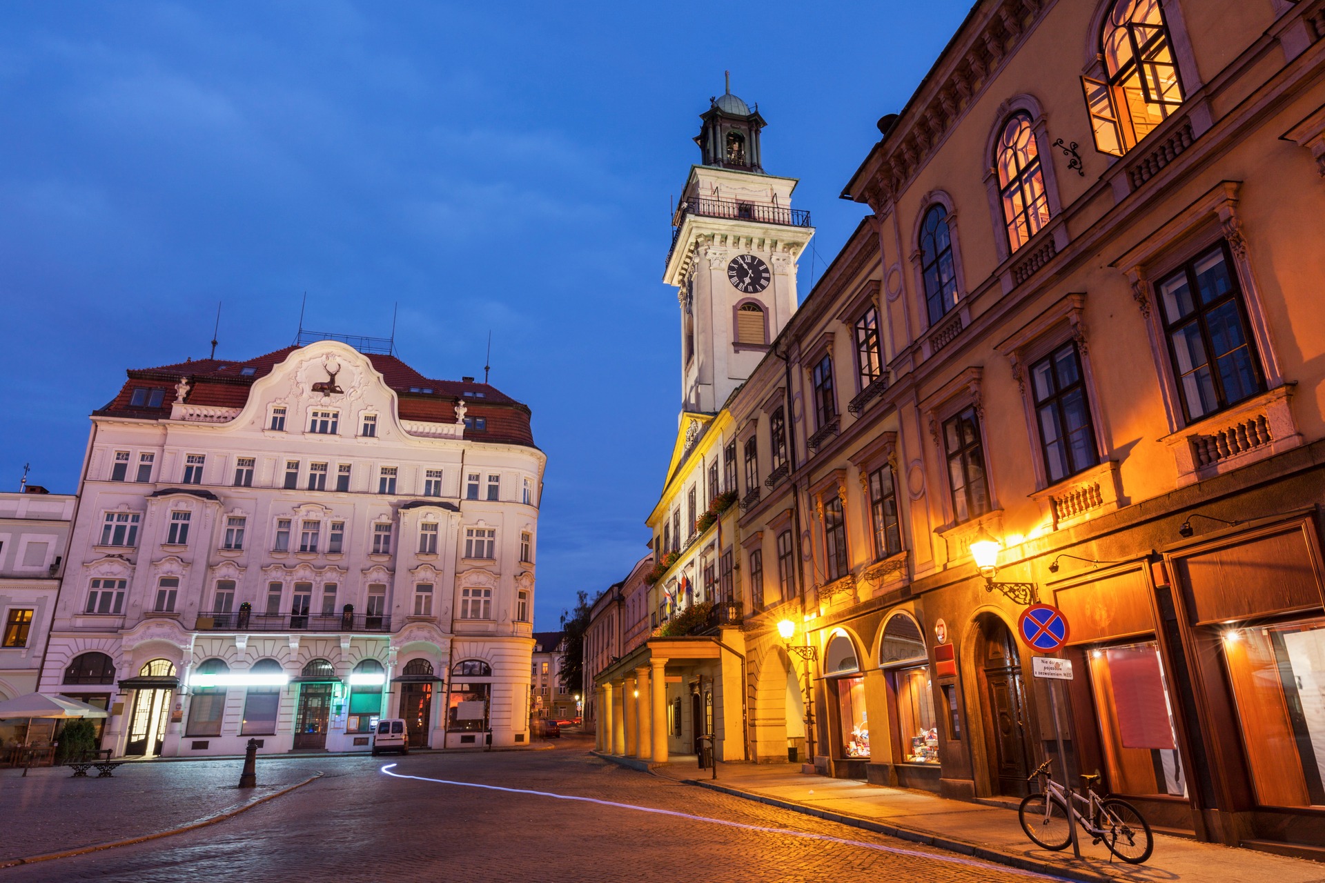 Rynek v Cieszyně za soumraku s osvětlenou klasicistní radnicí a kašnou