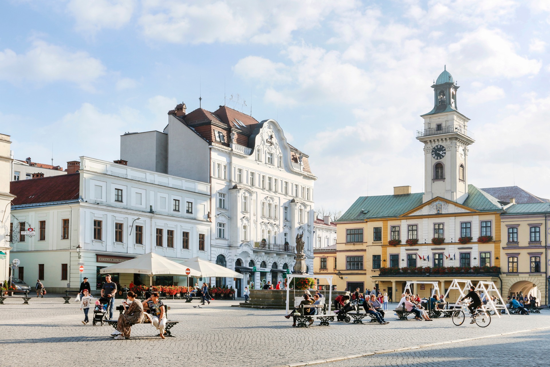 Rynek v Cieszyně za slunečného dne s podloubím a předzahrádkami kaváren