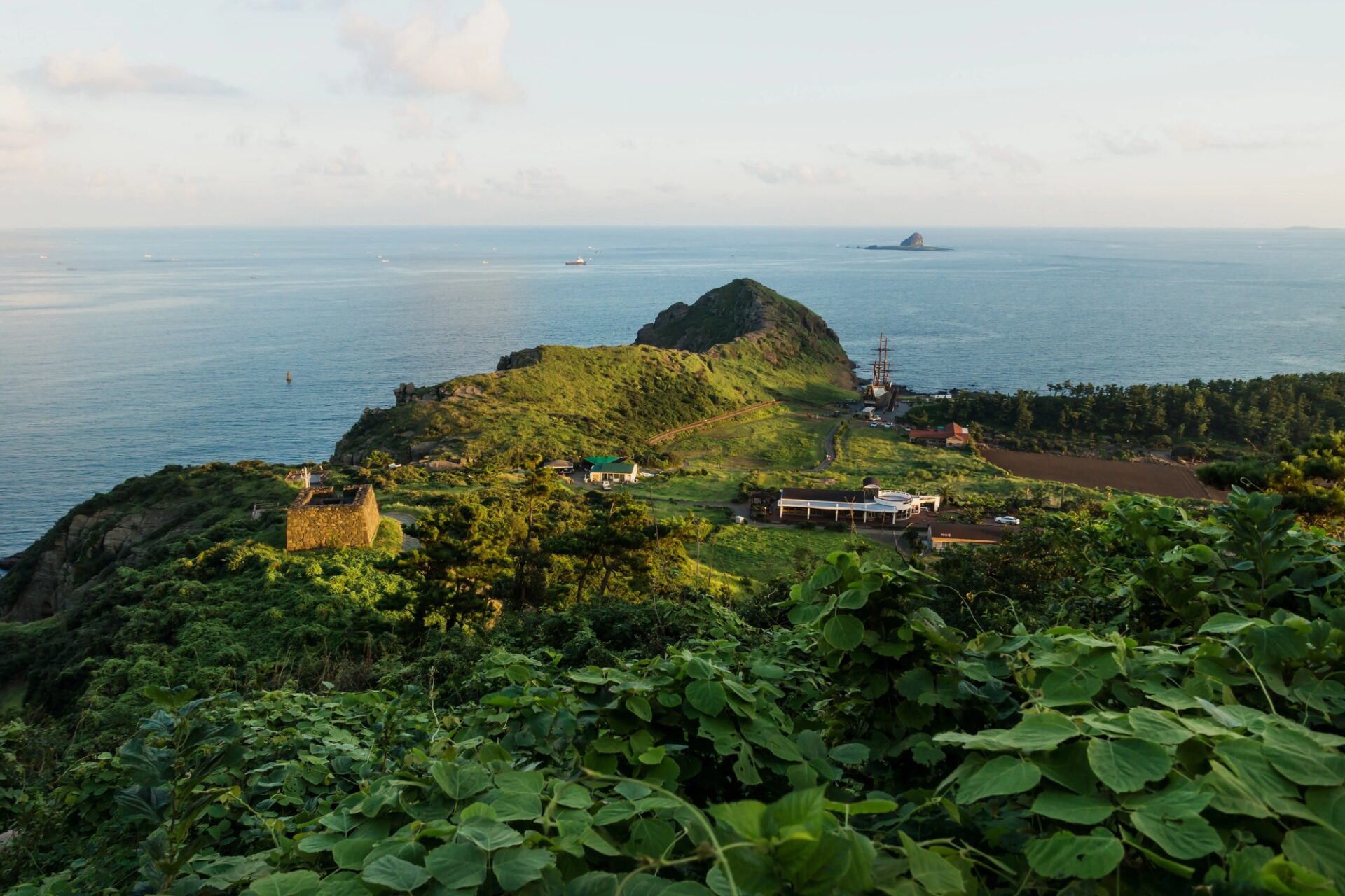 Pobřežní výhled na zelený sopečný kopec na ostrově Jeju