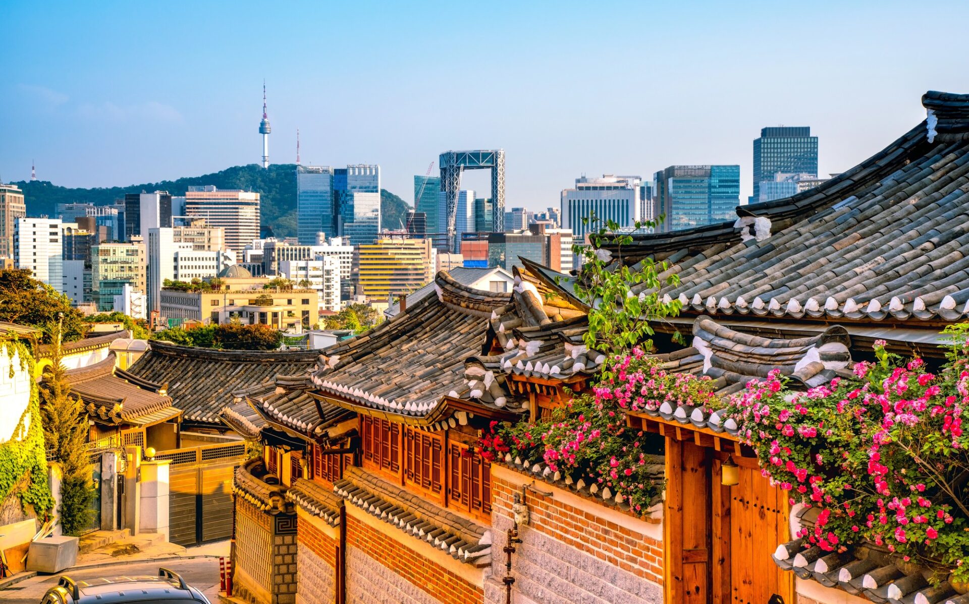 Tradiční čtvrť hanok v Soulu s městským panoramatem v pozadí