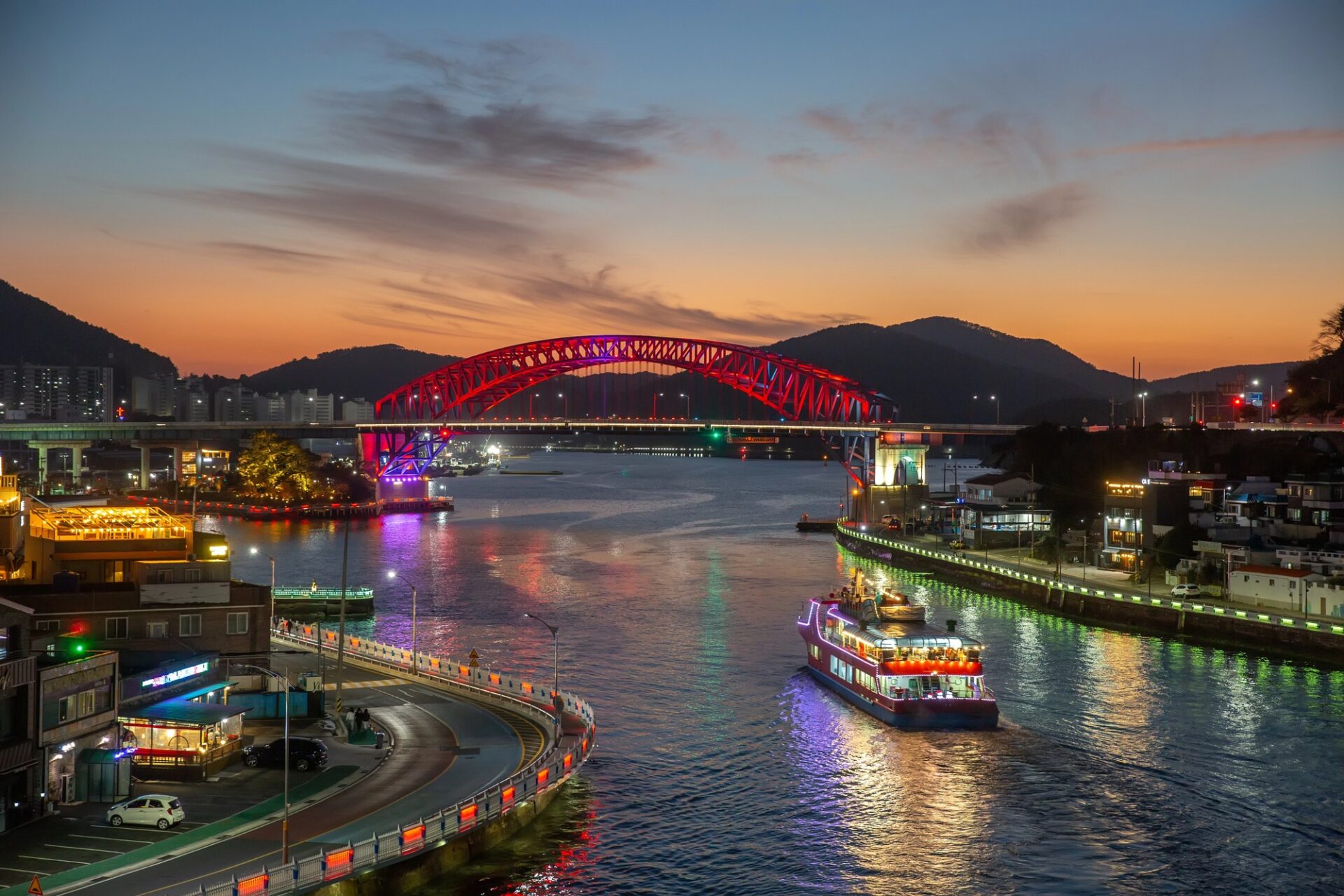Noční Yeosu Noční pobřeží Yeosu s osvětleným mostem a loděmi na vodě