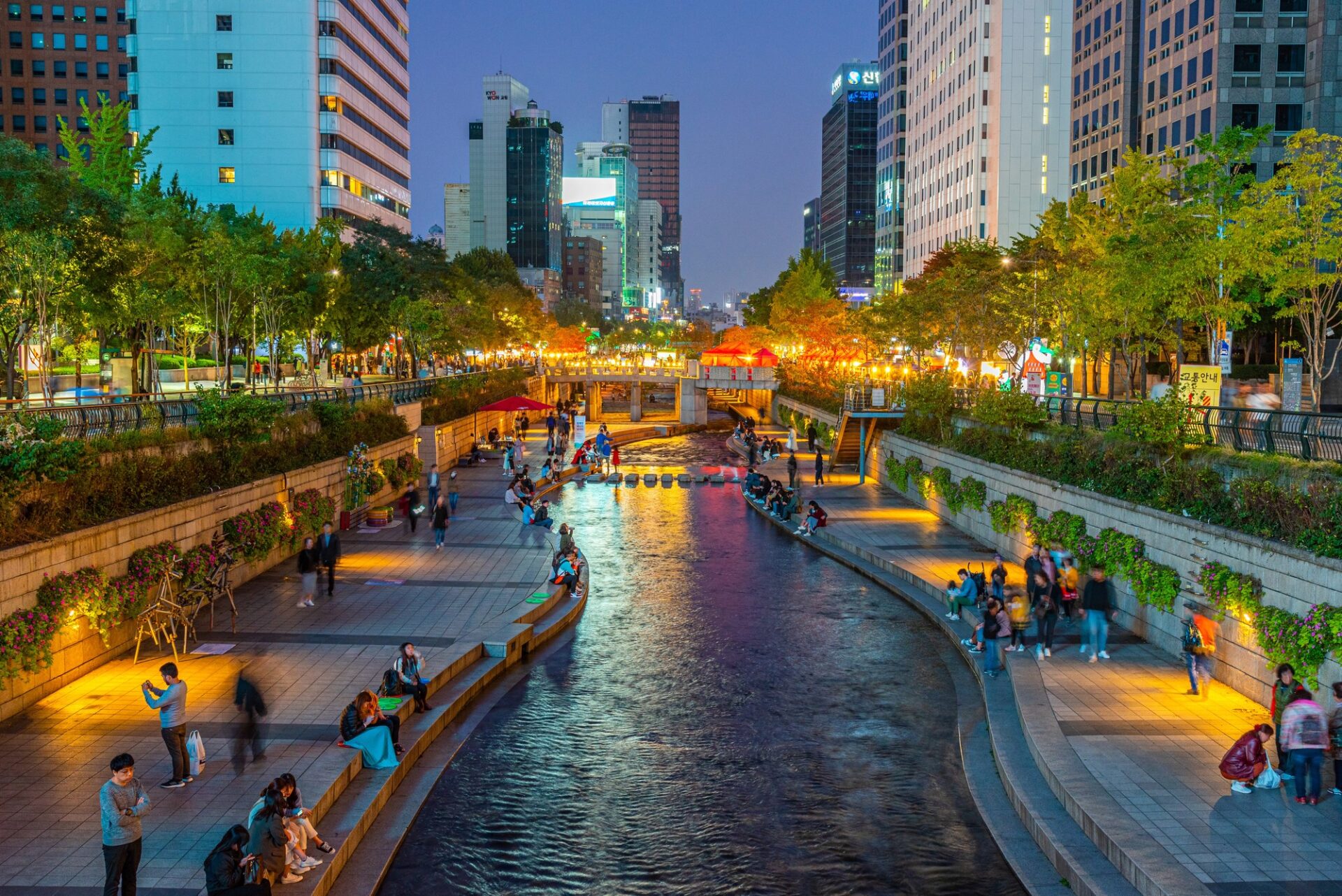 Večerní promenáda Cheonggyecheon v centru Soulu s osvětlenými budovami