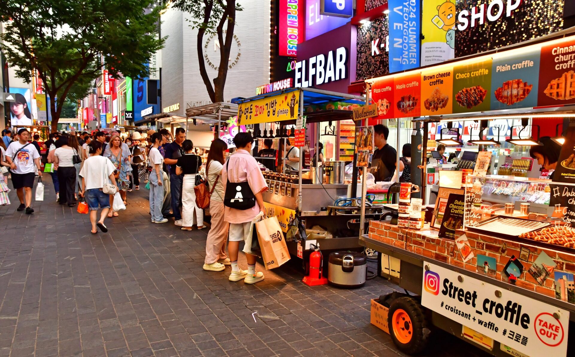 Rušná ulice Myeongdong v Soulu se stánky s jídlem a obchody