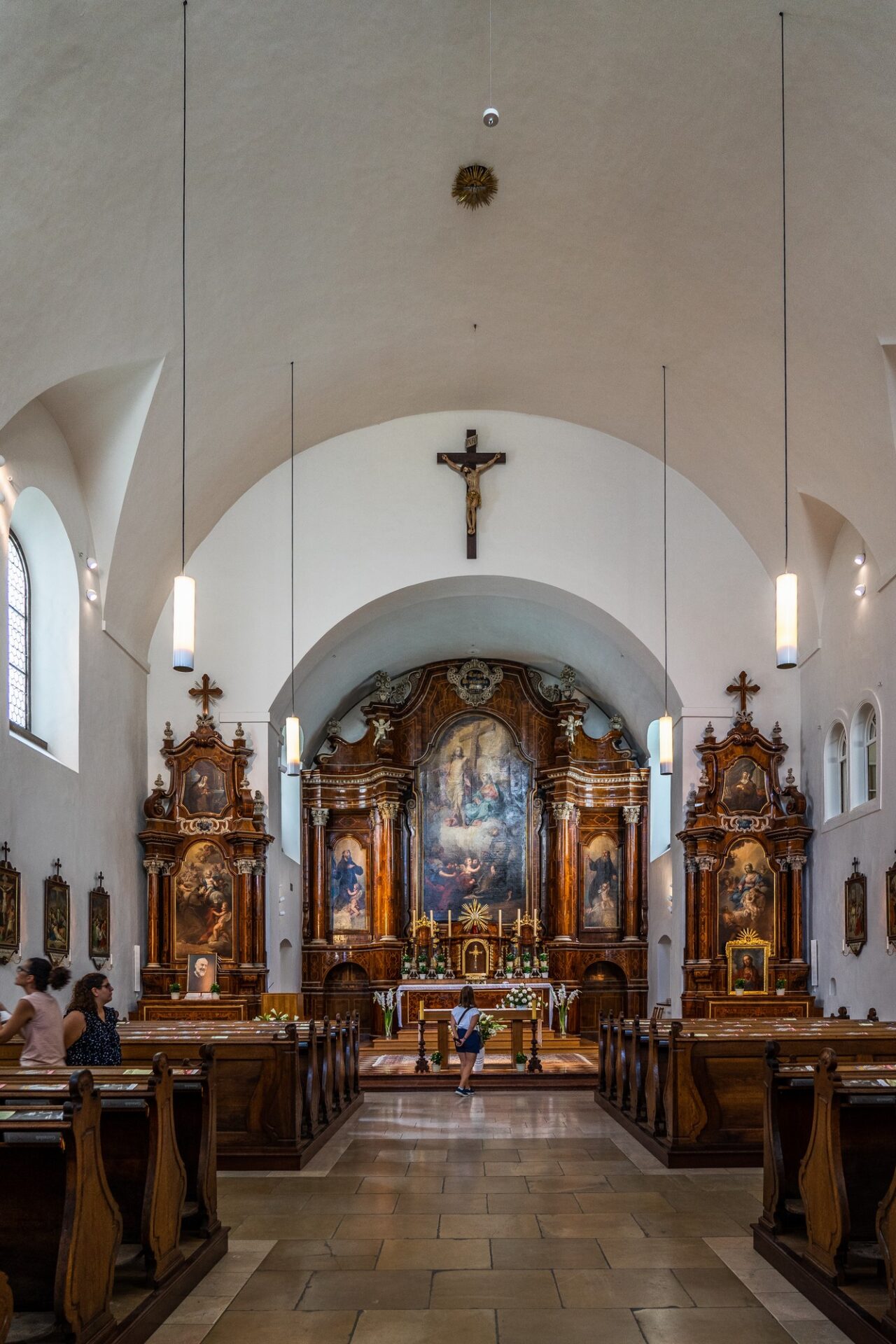 Interiér vídeňského kostela s oltářem a lavicemi