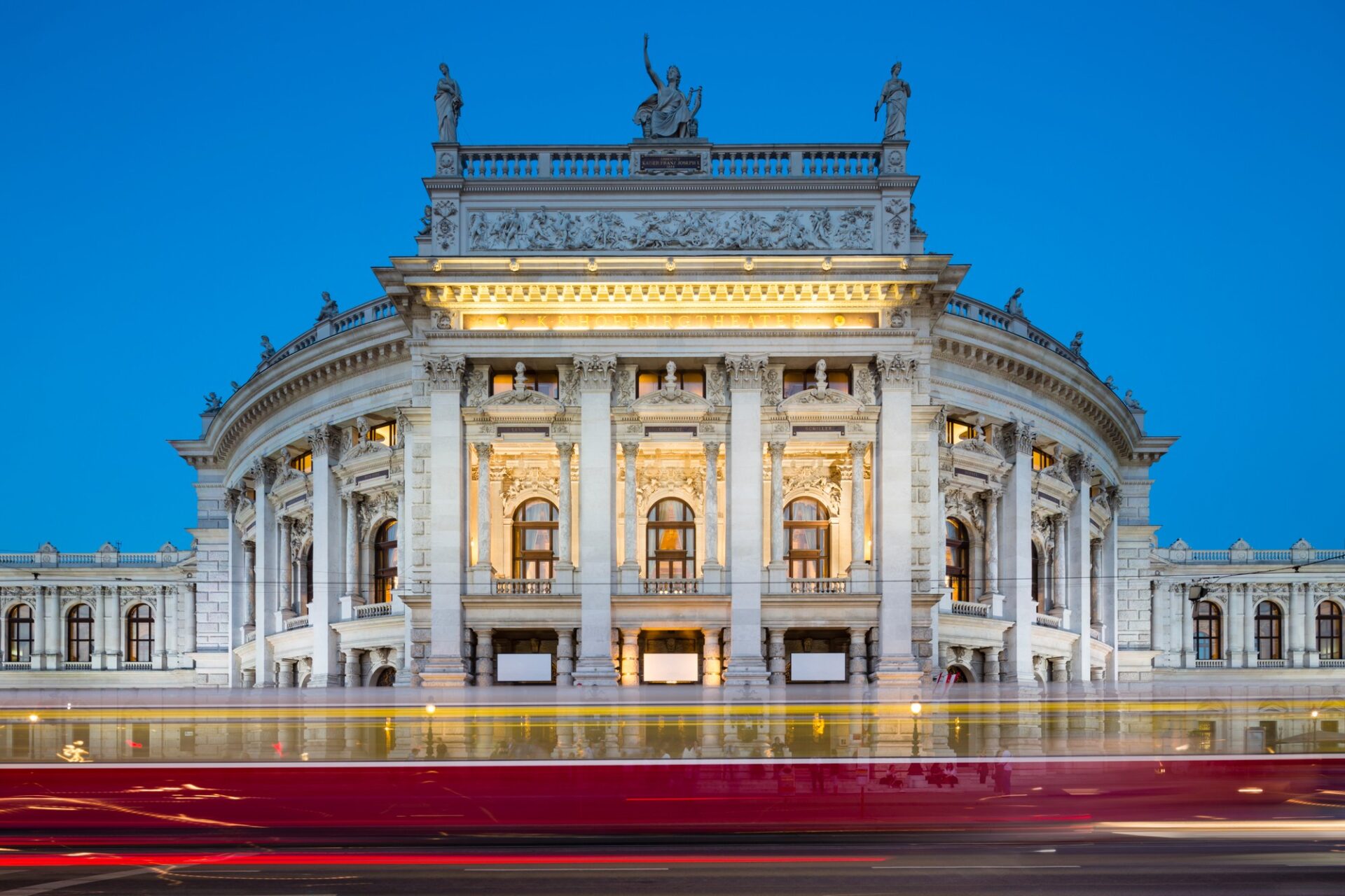 Burgtheater ve Vídni Burgtheater ve Vídni nasvícený večer s projíždějící tramvají