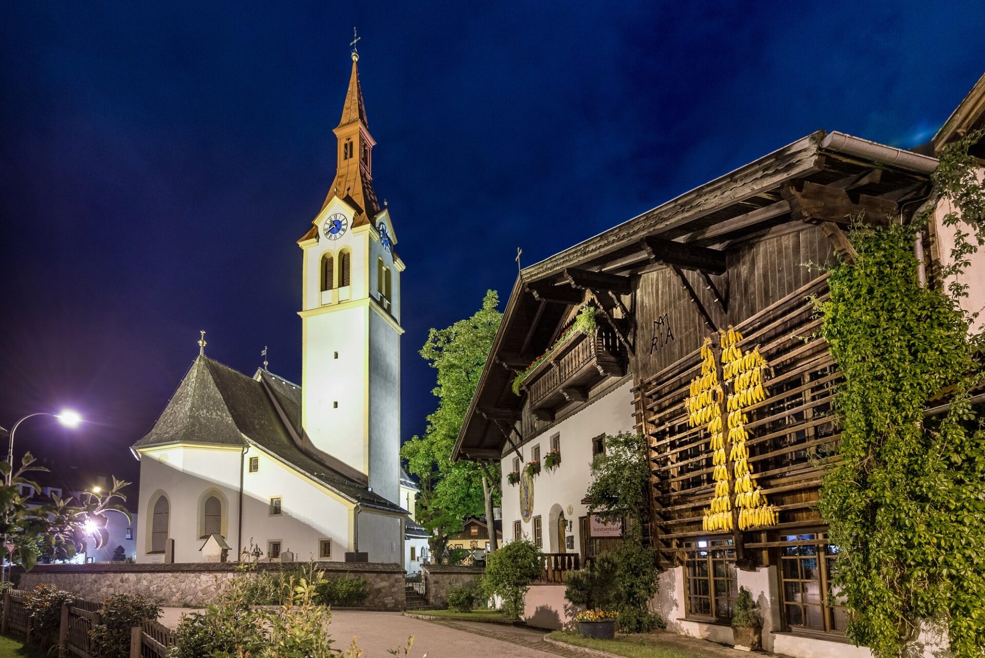 Vesnice v okolí Innsbrucku Vesnický kostel a tradiční dům v okolí Innsbrucku