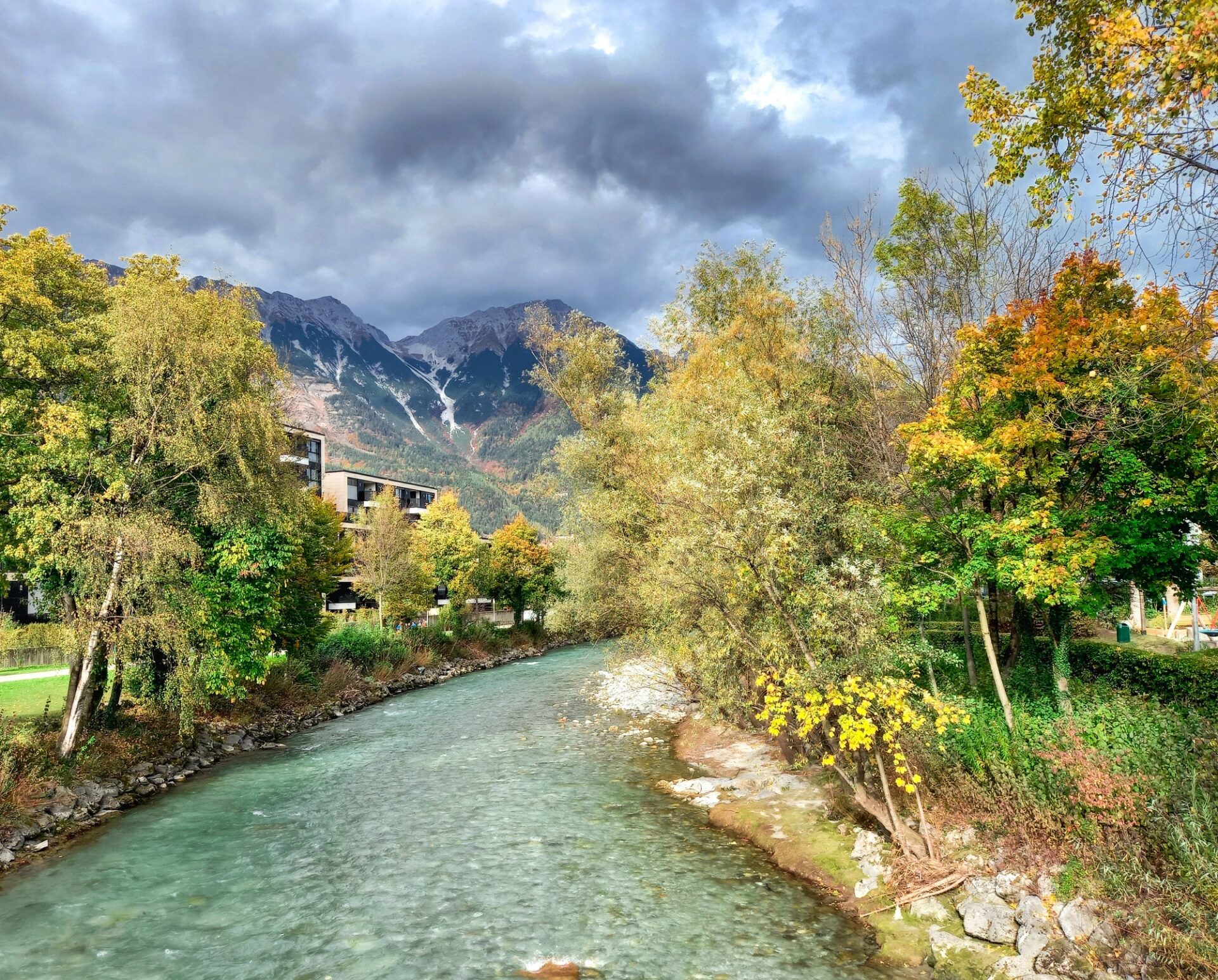 Podzim v Tyrolsku Řeka a podzimní stromy v alpské krajině u Innsbrucku