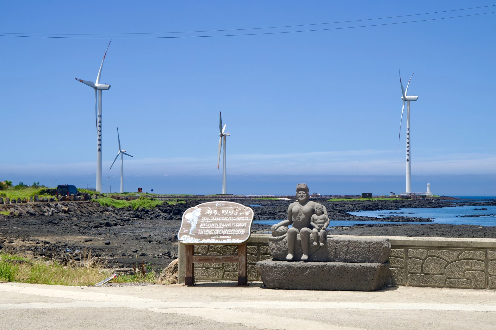 Socha haenyeo na lávovém pobřeží u Sinchangu na ostrově Jeju