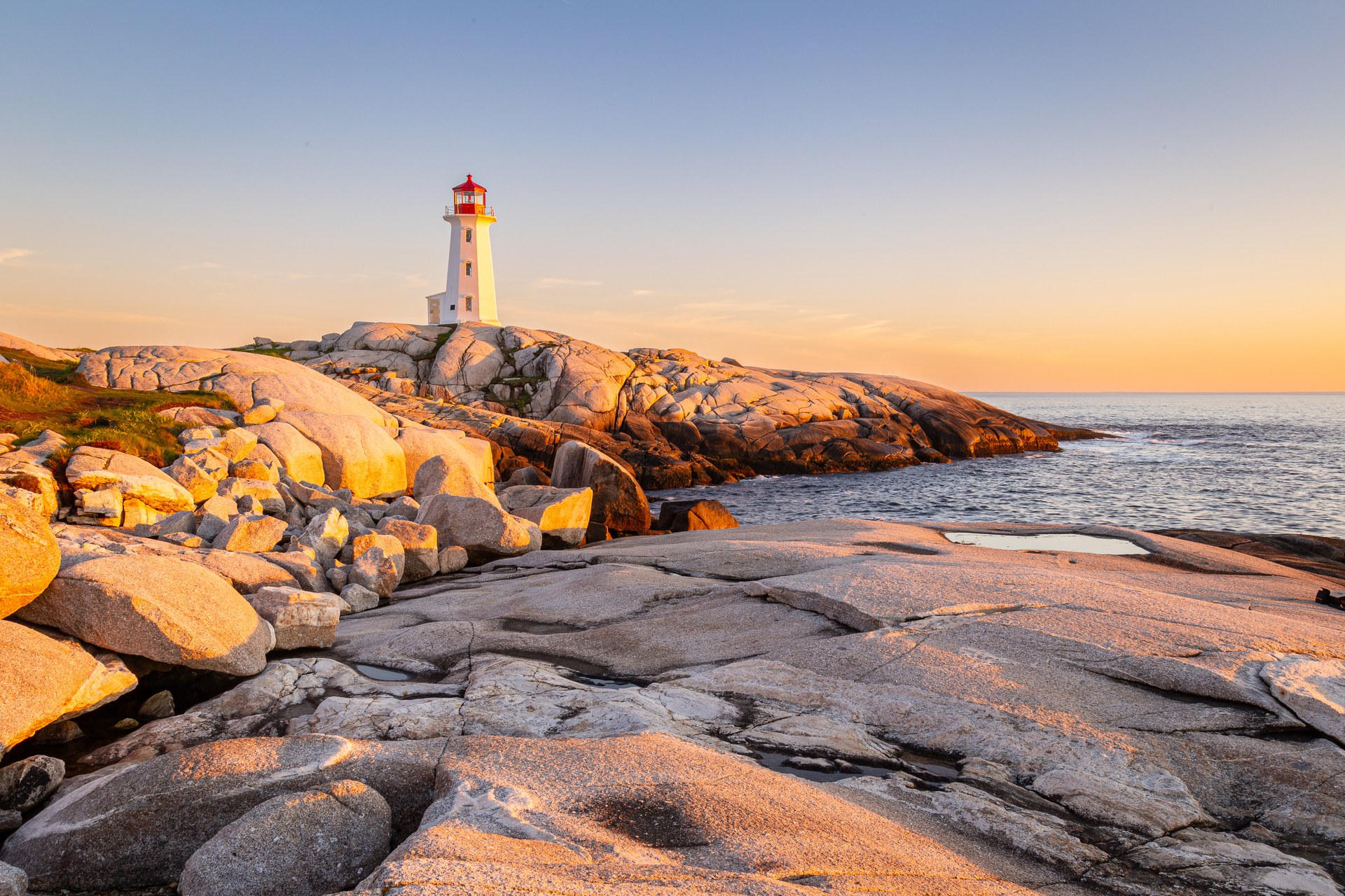 Maják Peggy’s Cove na žulovém pobřeží Nového Skotska při západu slunce