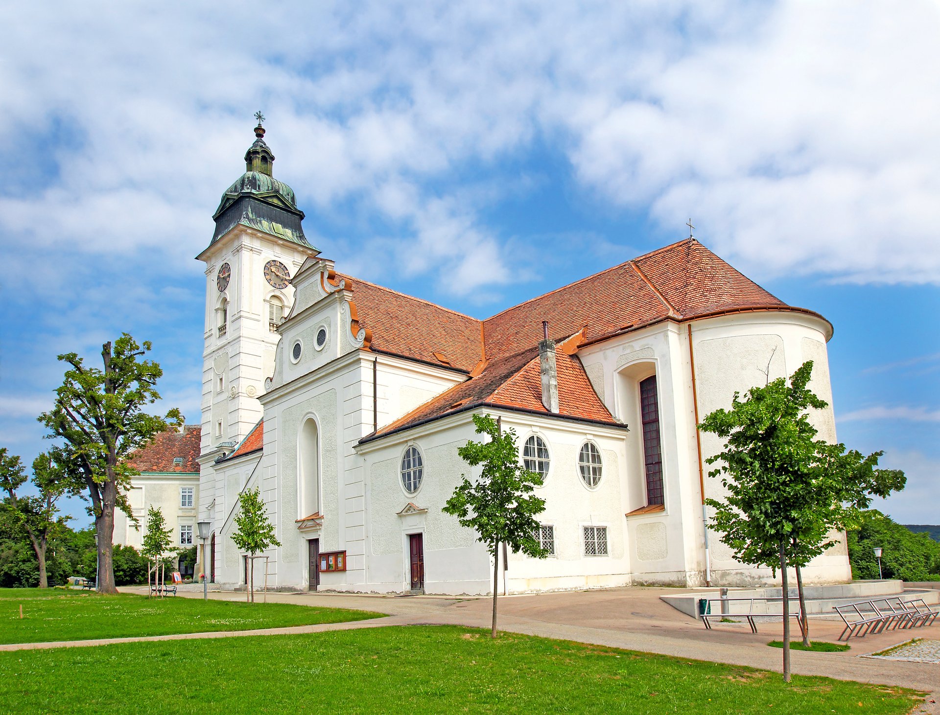 Bílá barokní fasáda a věž kostela svatého Štěpána v Retzu